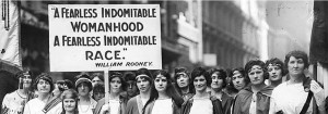 a group of women holding a sign that says "A Fearless Indomitable Womanhood A Fearless Indomitable Race"