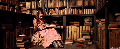 A gif of a young women reading in a library