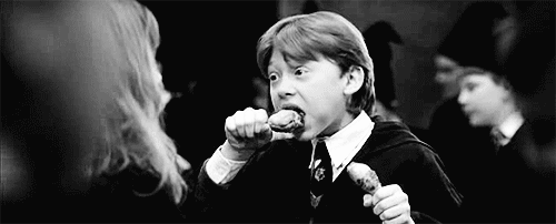 A gif of Ron from Harry Potter eating chicken