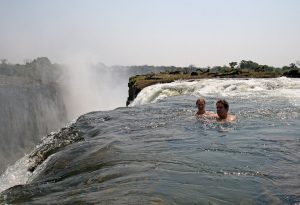 An image of a man and a woman swimming in Victoria Falls