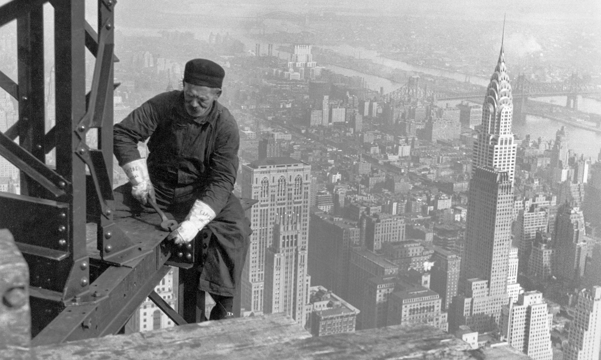 A black and white image of a man working on a building in New York city