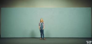 An image of a man standing in front of a blank wall